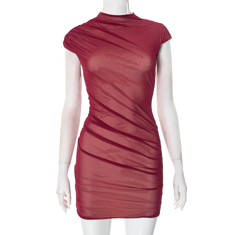 A mannequin wearing a short, form-fitting burgundy dress with sheer fabric and ruching.