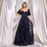 A woman in a navy blue, floor-length A-line gown with a sweetheart neckline and short flutter sleeves.