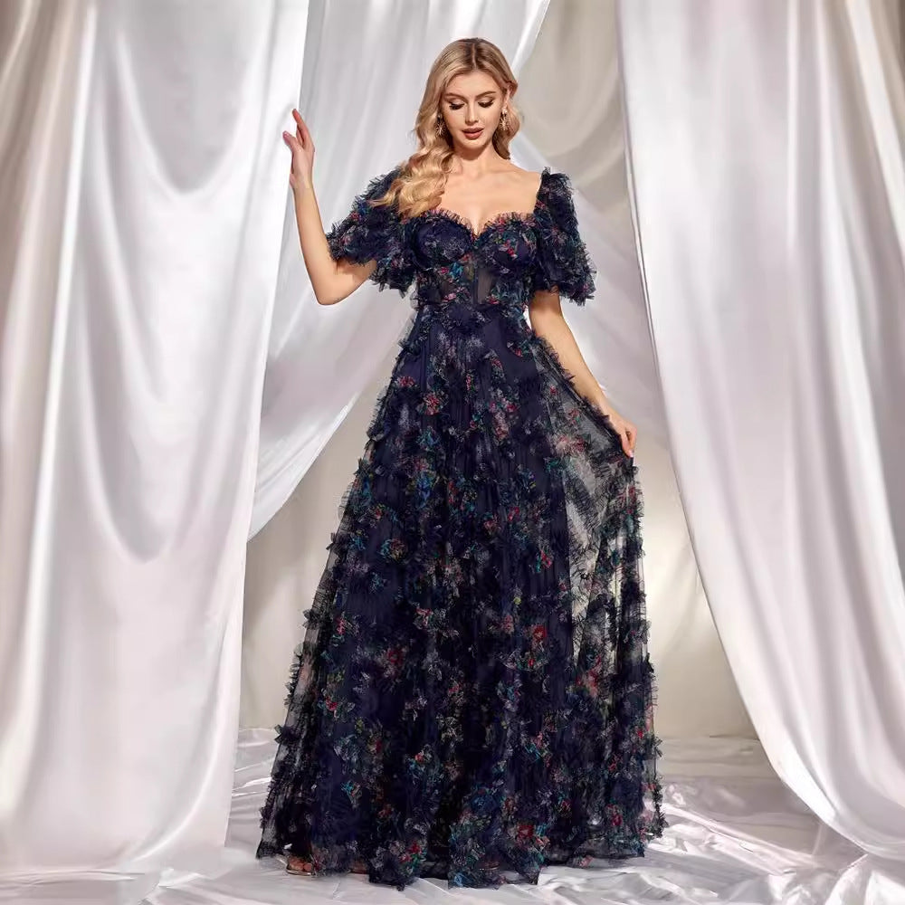 A woman in a navy blue, floor-length A-line gown with a sweetheart neckline and short flutter sleeves.