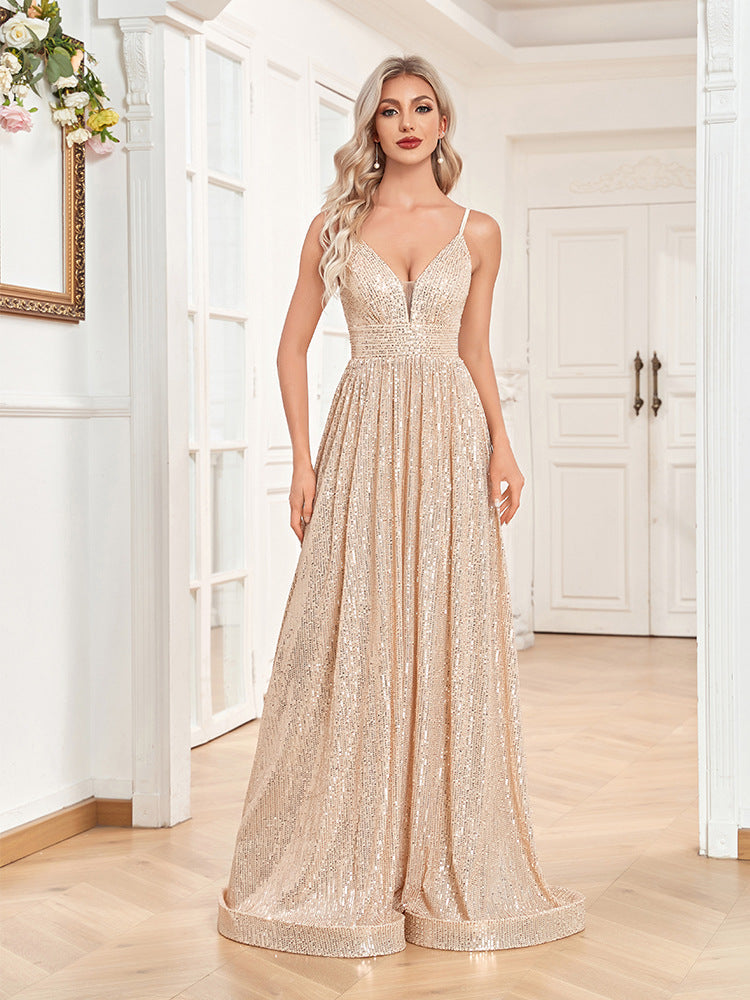 Woman in a gold sequined floor-length dress with spaghetti straps and a v-neck