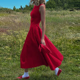 woman in red dress walking in a field