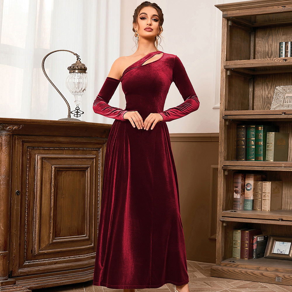 woman wearing a red velvet one-shoulder dress with a cut-out detail and long sleeves