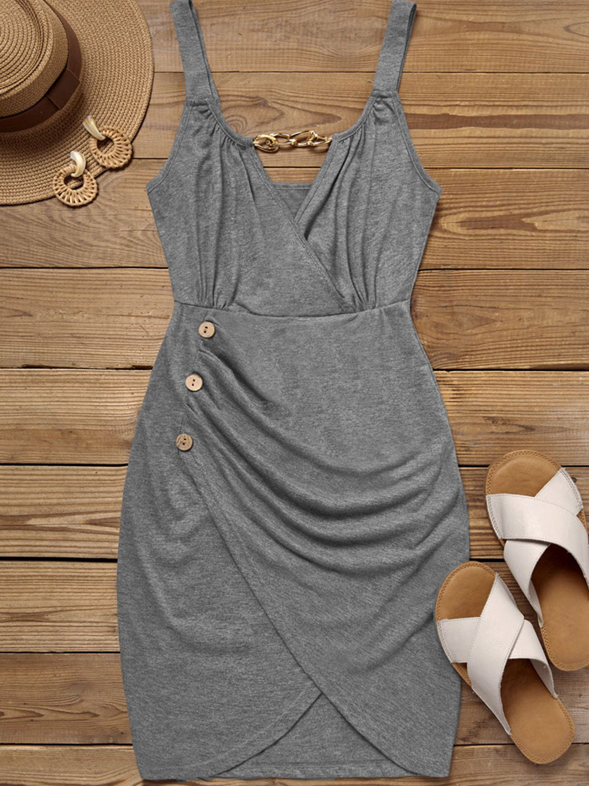flat lay of a gray dress with a straw hat, earrings, and sandals