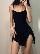 woman posing in black slip dress with high slit