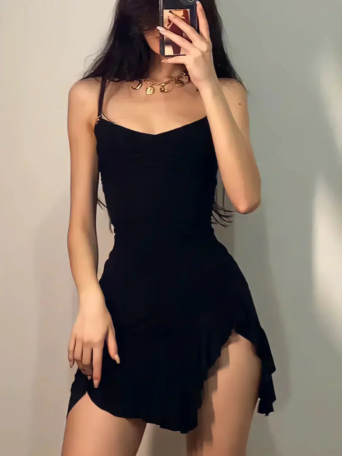 woman taking selfie in black cocktail dress