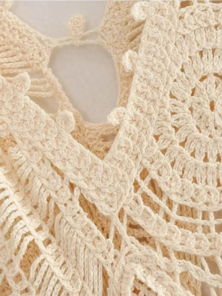 Close-up of the intricate crochet detailing on a cream-colored dress.