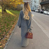 woman from behind wearing a long gray cardigan dress