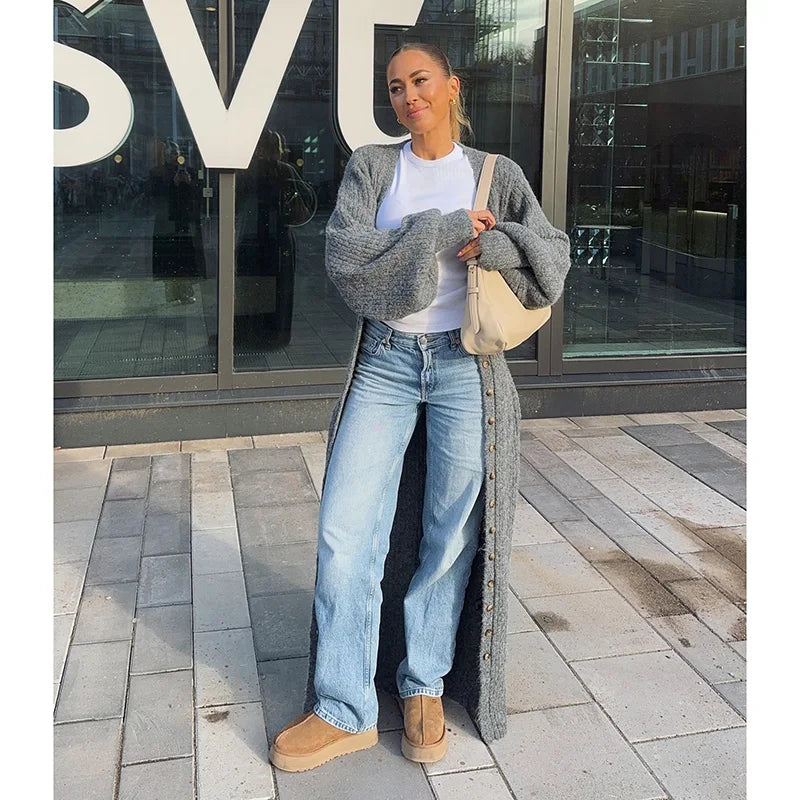 woman wearing a long gray cardigan, white t-shirt, and light blue jeans