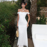 woman wearing a white lace off-the-shoulder dress outdoors