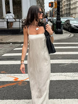 woman in beige slip dress walking on a crosswalk