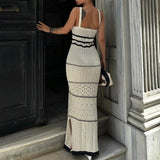 Woman wearing a beige knit maxi dress with black trim from the back