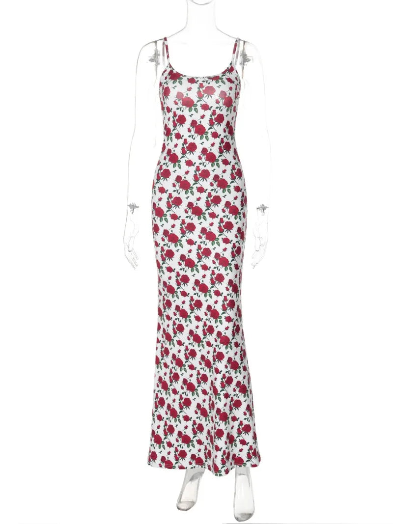 A white maxi dress with a red rose print is displayed on a mannequin.