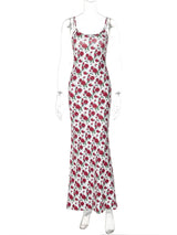 A white maxi dress with a red rose print is displayed on a mannequin.