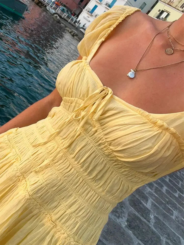 Close-up of the smocked bodice and tie-front detail of a yellow dress