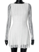 White lace dress displayed on a mannequin with black gloves.