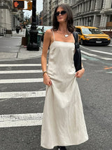 woman in beige maxi dress standing on a crosswalk