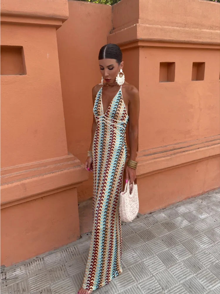 Full-body shot of a woman in a patterned maxi dress, posing outdoors.