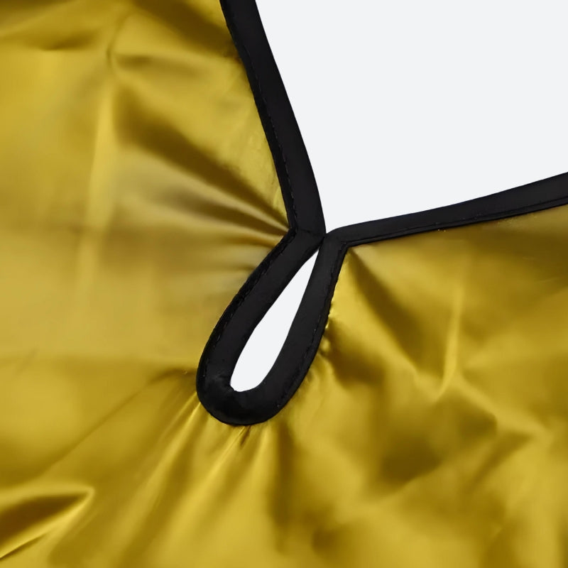 A close-up view of the neckline of a long, yellow dress with a black trim. The neckline has a cutout detail and a loop.