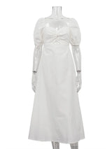A white midi dress with puff sleeves, a sweetheart neckline with a twist front detail, and a cut-out at the waist, displayed on a mannequin.