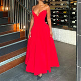 Woman in a red satin strapless dress with a full skirt, standing near a staircase and wine racks.