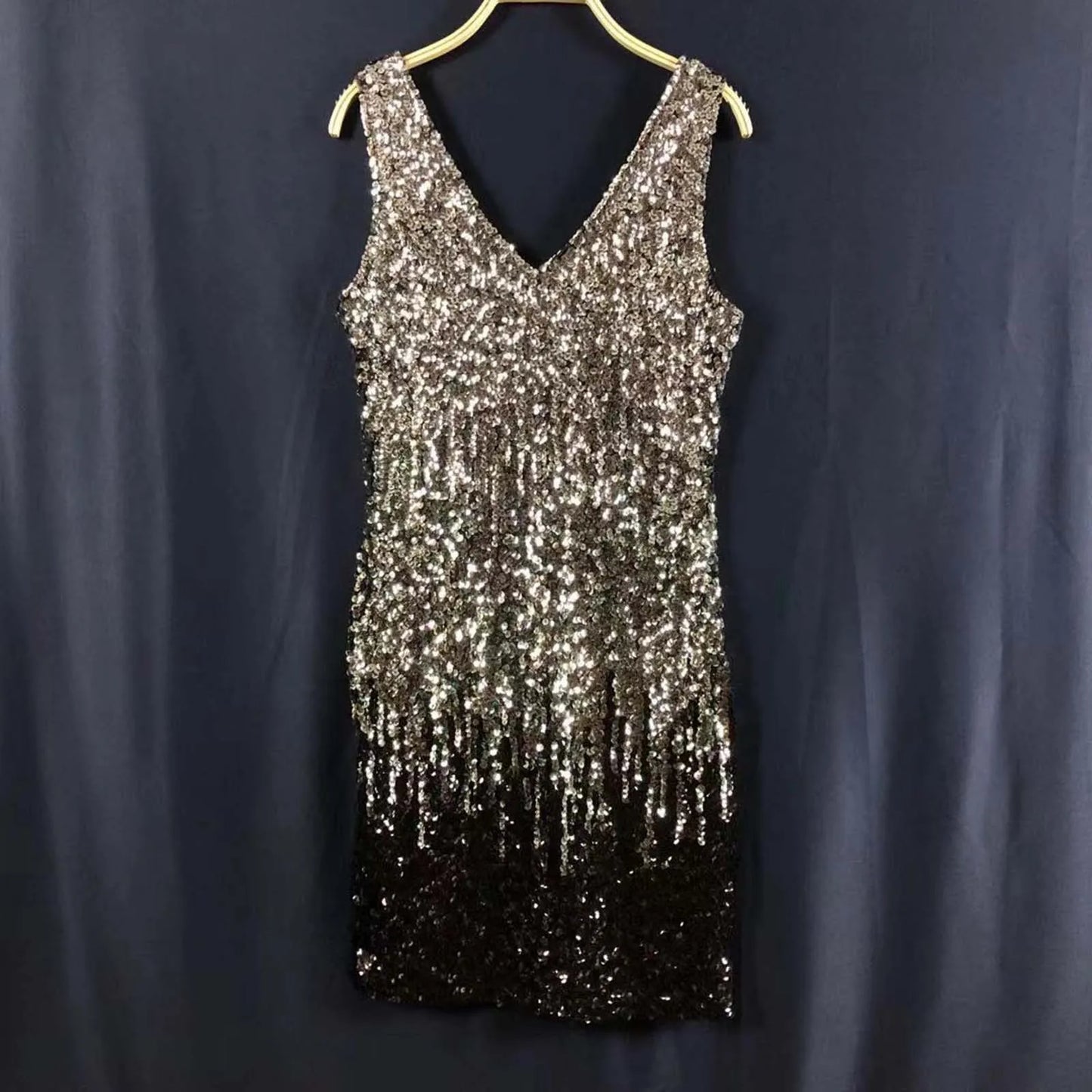 A sleeveless V-neck sequined dress with a silver to black ombre effect.