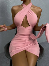 woman wearing a pink halter neck cutout dress with ruched skirt