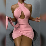 A woman in a pink halter neck dress with a cut-out and ruching is sitting on a chair.