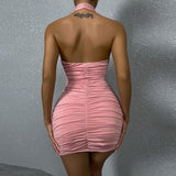 The back of a woman in a pink ruched halter neck dress.