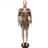 Mannequin wearing a bronze satin mini dress with a tie waist and long sleeves.