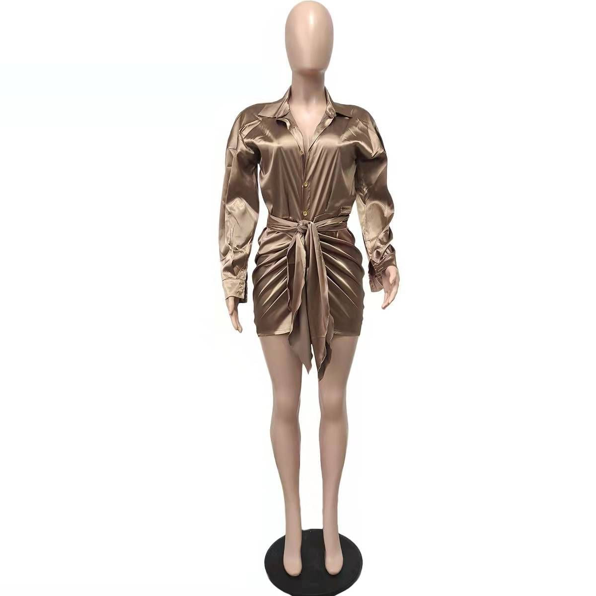 Mannequin wearing a bronze satin mini dress with a tie waist and long sleeves.