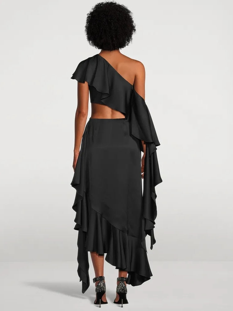 A black one-shoulder dress with ruffles and a cut-out, shown from the side