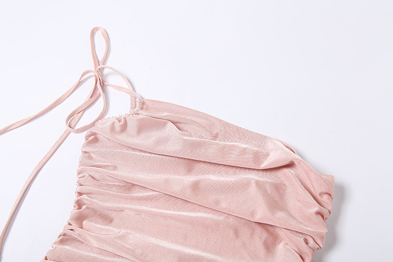 Close-up of the ruched fabric and tie detail on a pink one-shoulder dress