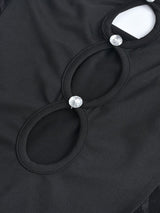 Close-up of the cut-out details on a black strapless dress, featuring embellishments.