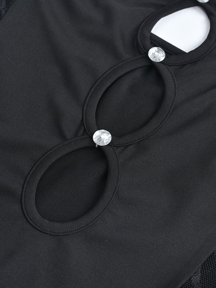 Close-up of the cut-out details on a black strapless dress, featuring embellishments.