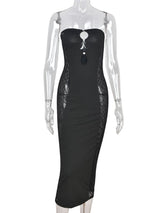 Mannequin displaying a black strapless bodycon maxi dress with cut-out details and sheer side panels.