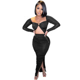 woman wearing a black ruched two-piece set with a cutout top and high slit skirt