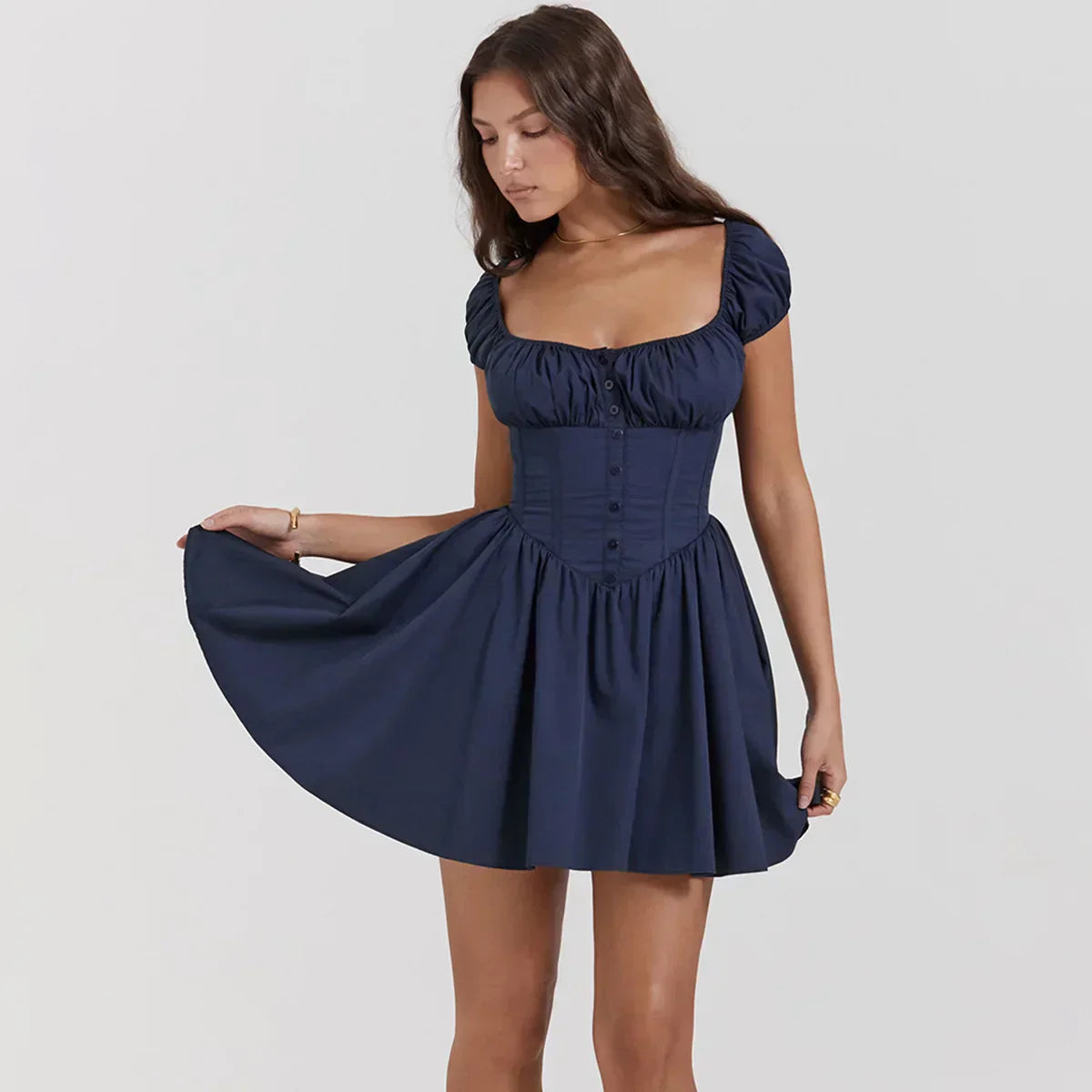 A woman wearing a navy blue short dress with puffy sleeves and a corset bodice, lifting the skirt.