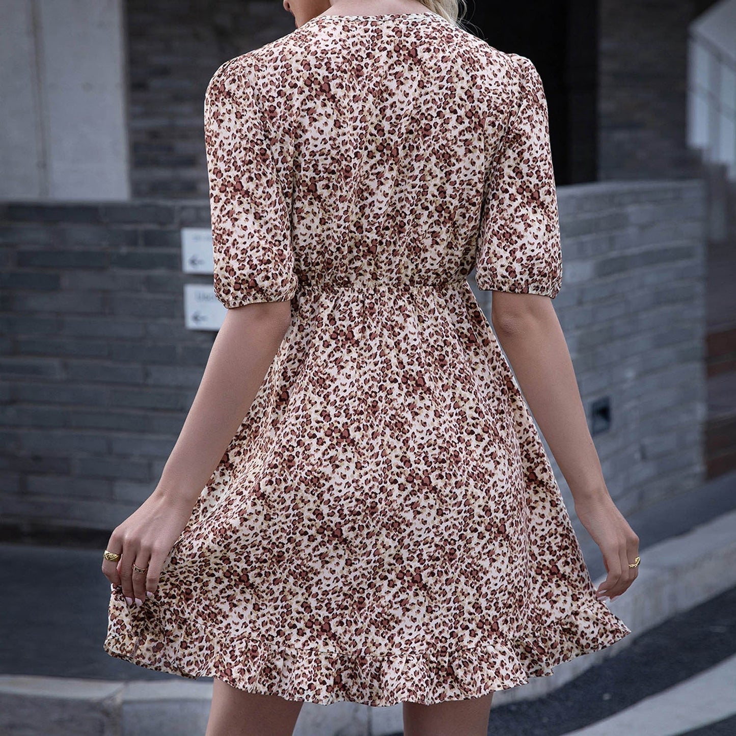 Back view of a woman wearing a floral print mini dress with short puff sleeves
