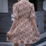 Back view of a woman wearing a floral print mini dress with short puff sleeves