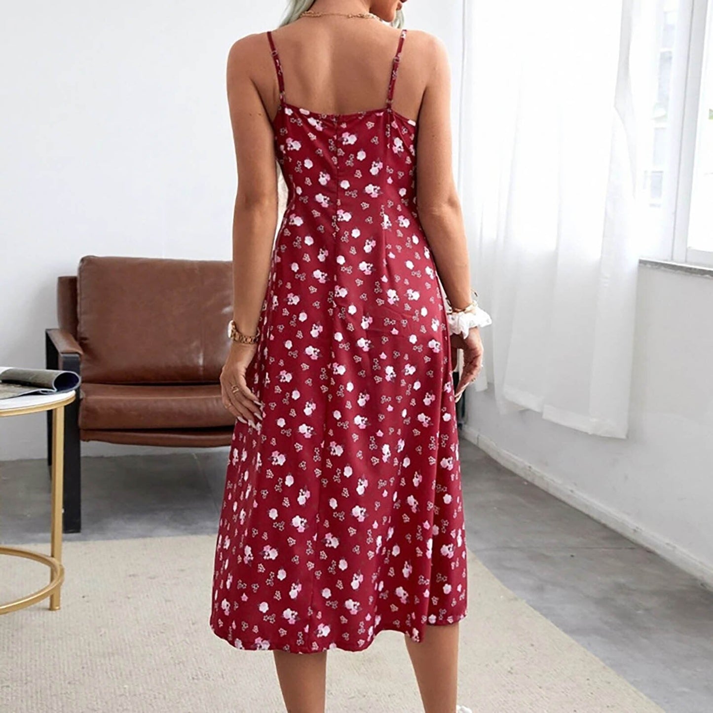 Woman wearing a red floral print midi dress with spaghetti straps from behind