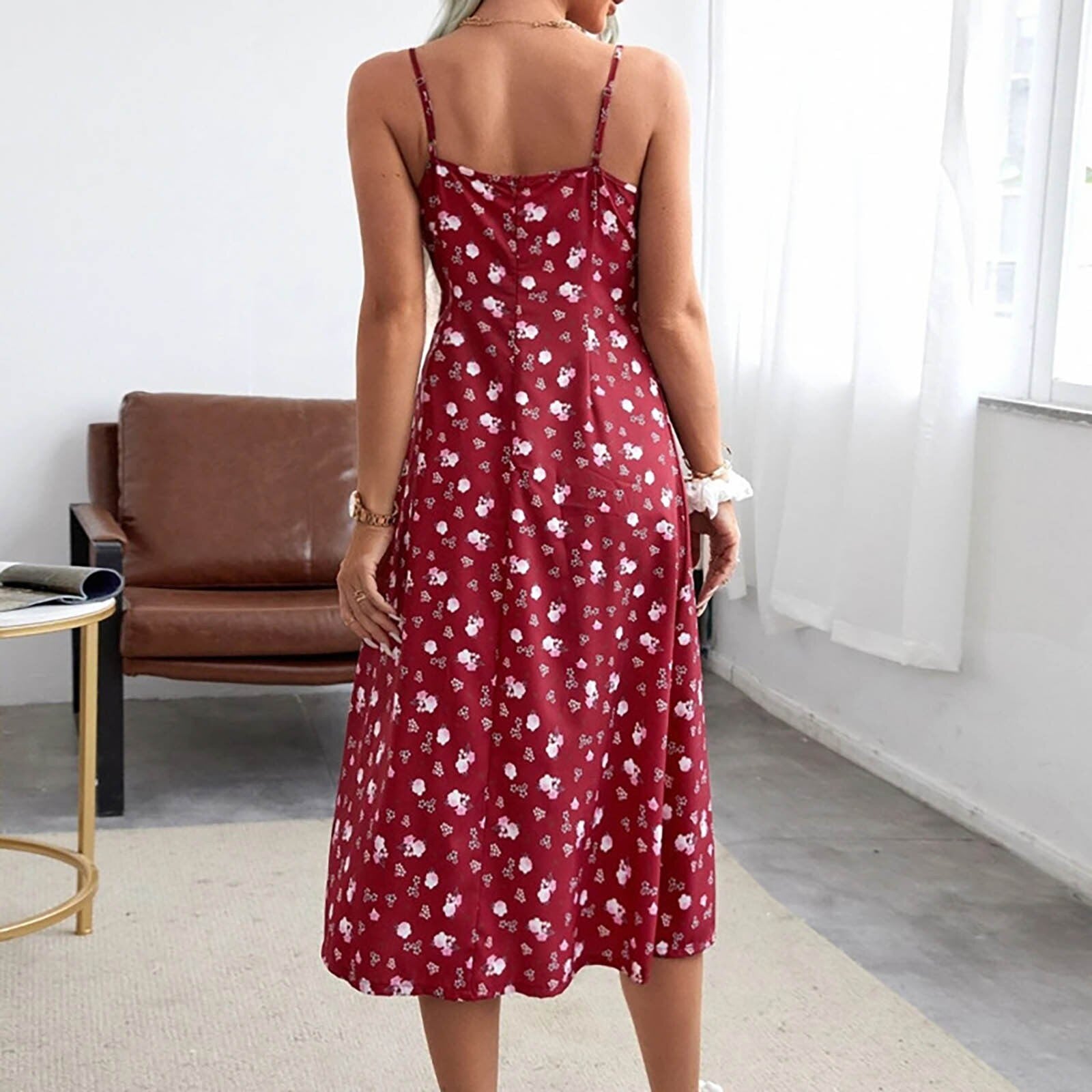 Woman wearing a red floral print midi dress with spaghetti straps from behind