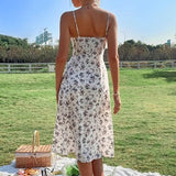 Woman wearing a white floral print midi dress with spaghetti straps from behind in a park