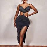 A woman posing in a black midi dress with a thigh-high slit and open back.