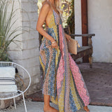 Woman in a colorful maxi dress standing outdoors.