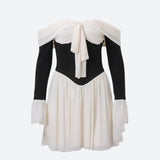 black and white off-the-shoulder dress with a bow detail and flared sleeves on a white background