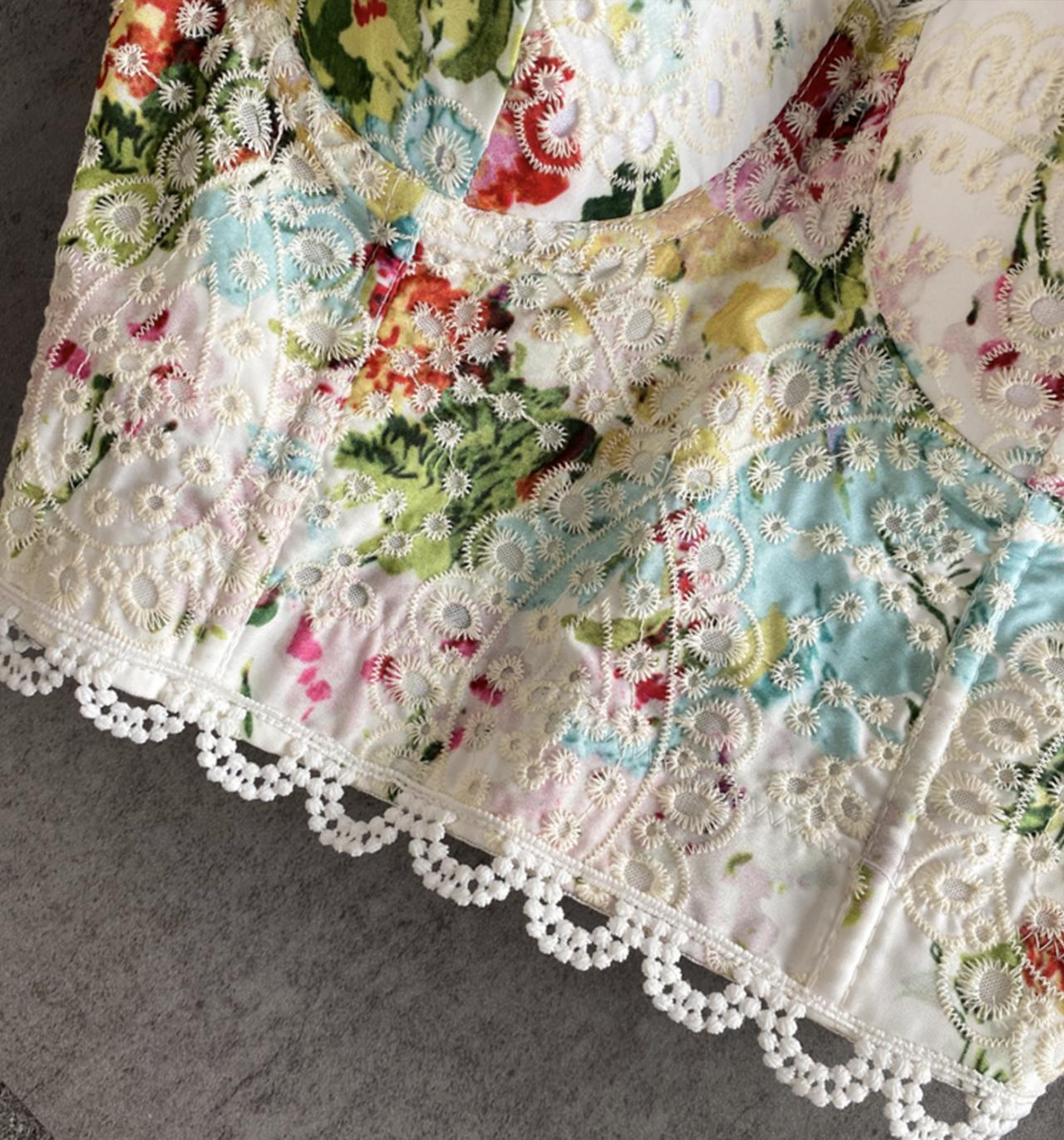 Detail of the embroidered lace and floral pattern on the corset top.