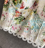 Detail of the embroidered lace and floral pattern on the corset top.