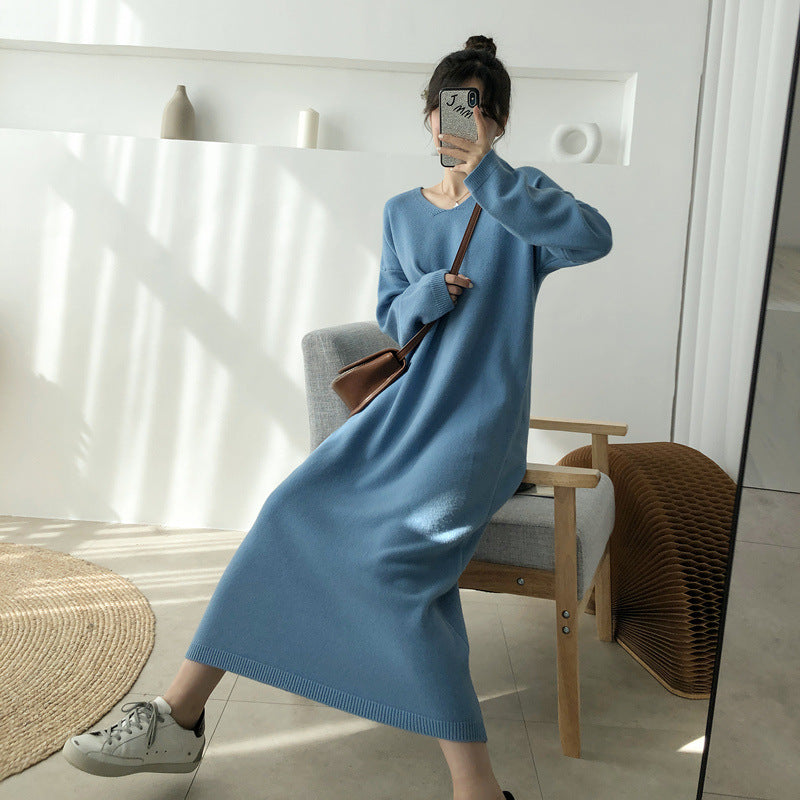 Woman sitting in a chair wearing a long blue knit dress