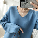 Close-up of a woman wearing a blue knit dress with a v-neckline