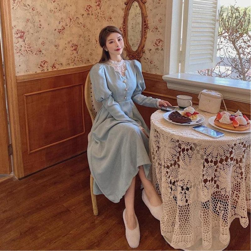 woman in light blue dress sitting at a table with dessert
